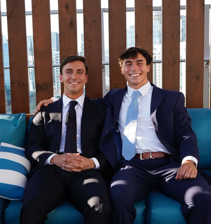 Jake Proffitt and Ethan Furgione seated together on a rooftop